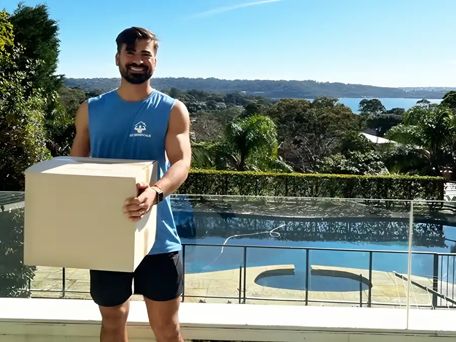 A Fit Removals mover carrying a packed box
